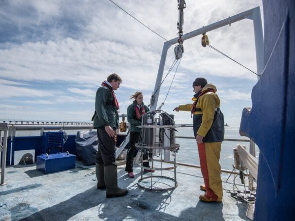 Scientists assembling sea water sampling experiment on research ship